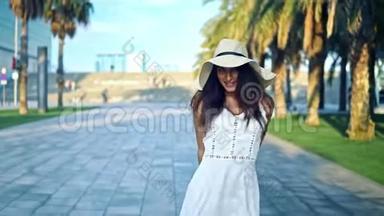 穿着白色裙子戴着帕梅拉帽子走路的漂亮女人